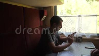 火车车厢上的人的剪影听着耳机上的音乐在信使社交媒体上留言